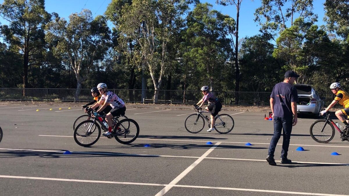 Women riding bikes at a skills session.